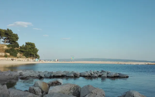 Der Strand Trstenik mit seiner Mole an einem ruhigen Morgen